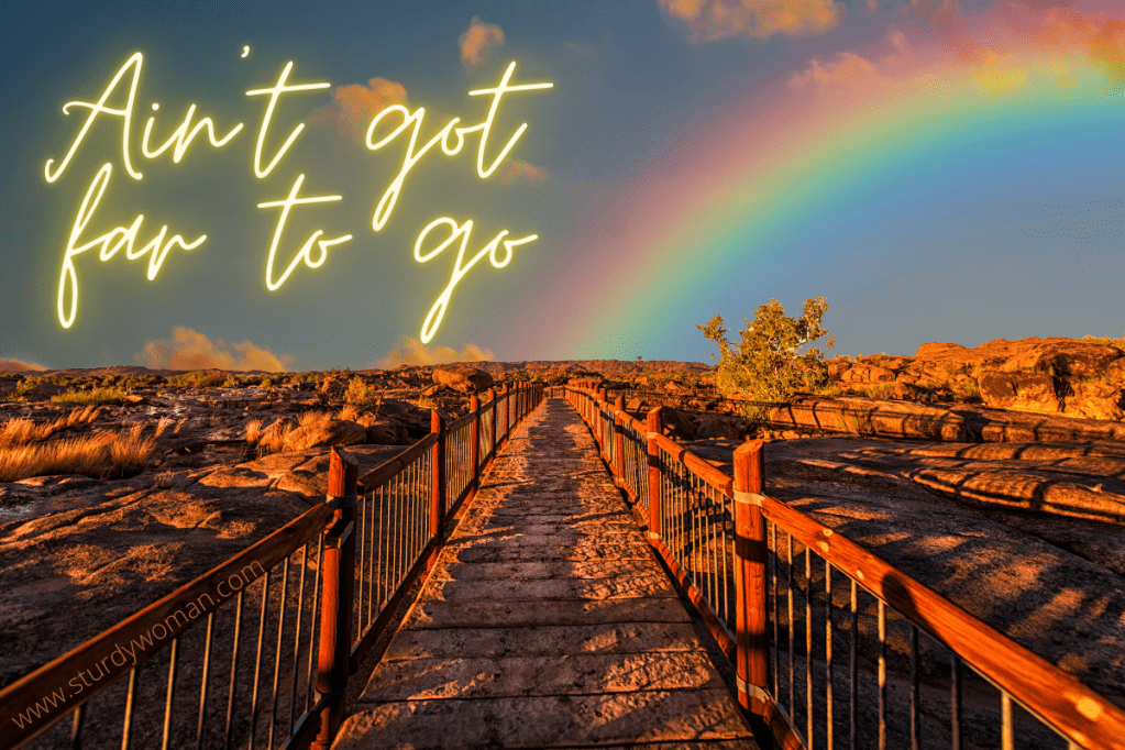 Path at sunseet with rainbow and motivation text to keep going